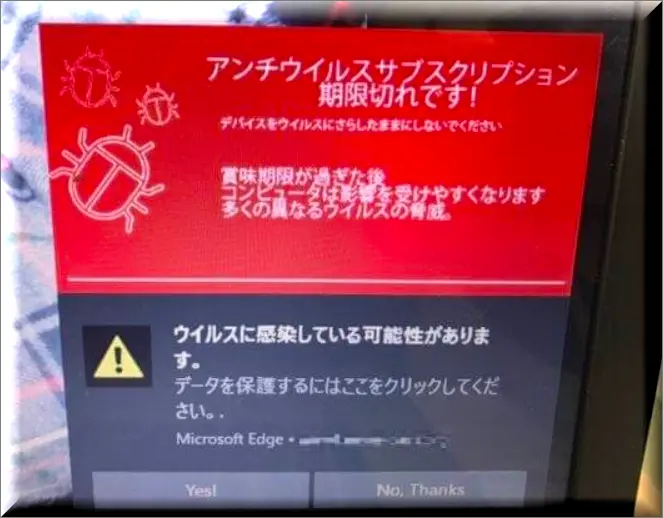 コンピュータの画面に表示されたポップアップ警告を注意深く見ているユーザー。これは、オンライン上の安全のためにウイルス警告メッセージの本物と偽物を見分けることの重要性を象徴している。